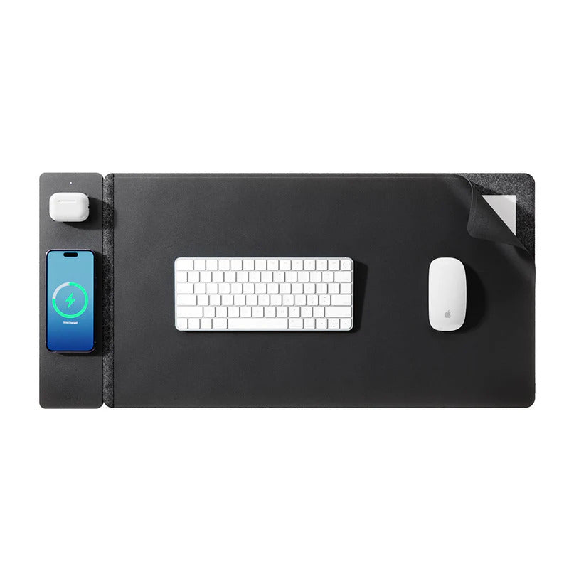 Black desk mat with phone, keyboard, and mouse on a white background